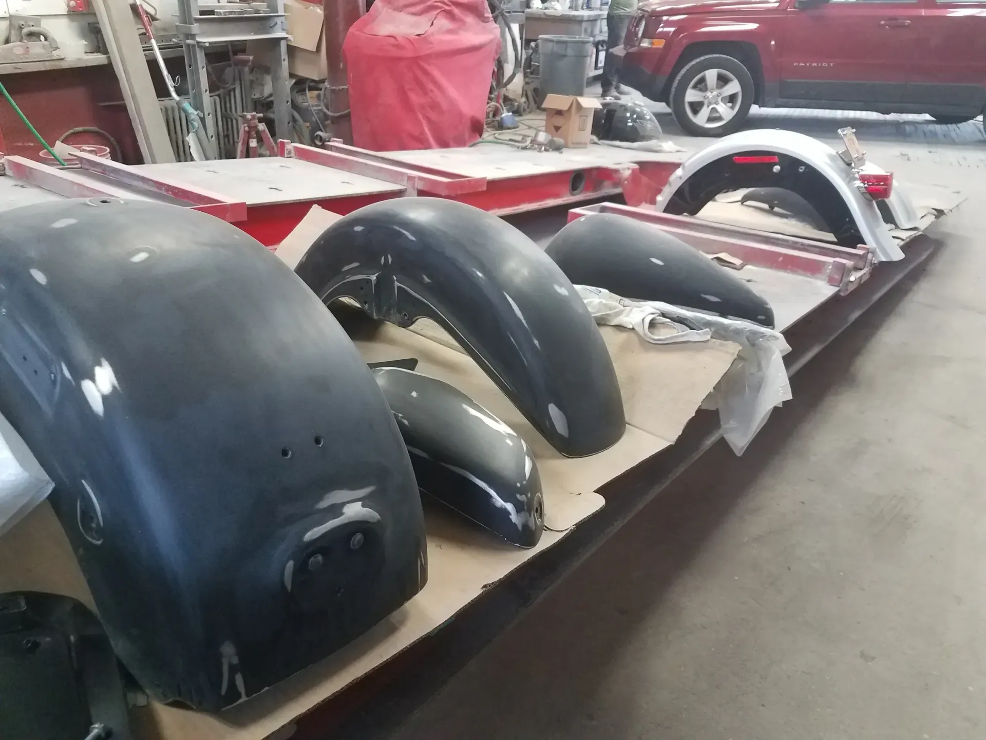 a bunch of fenders are sitting on a table in a garage