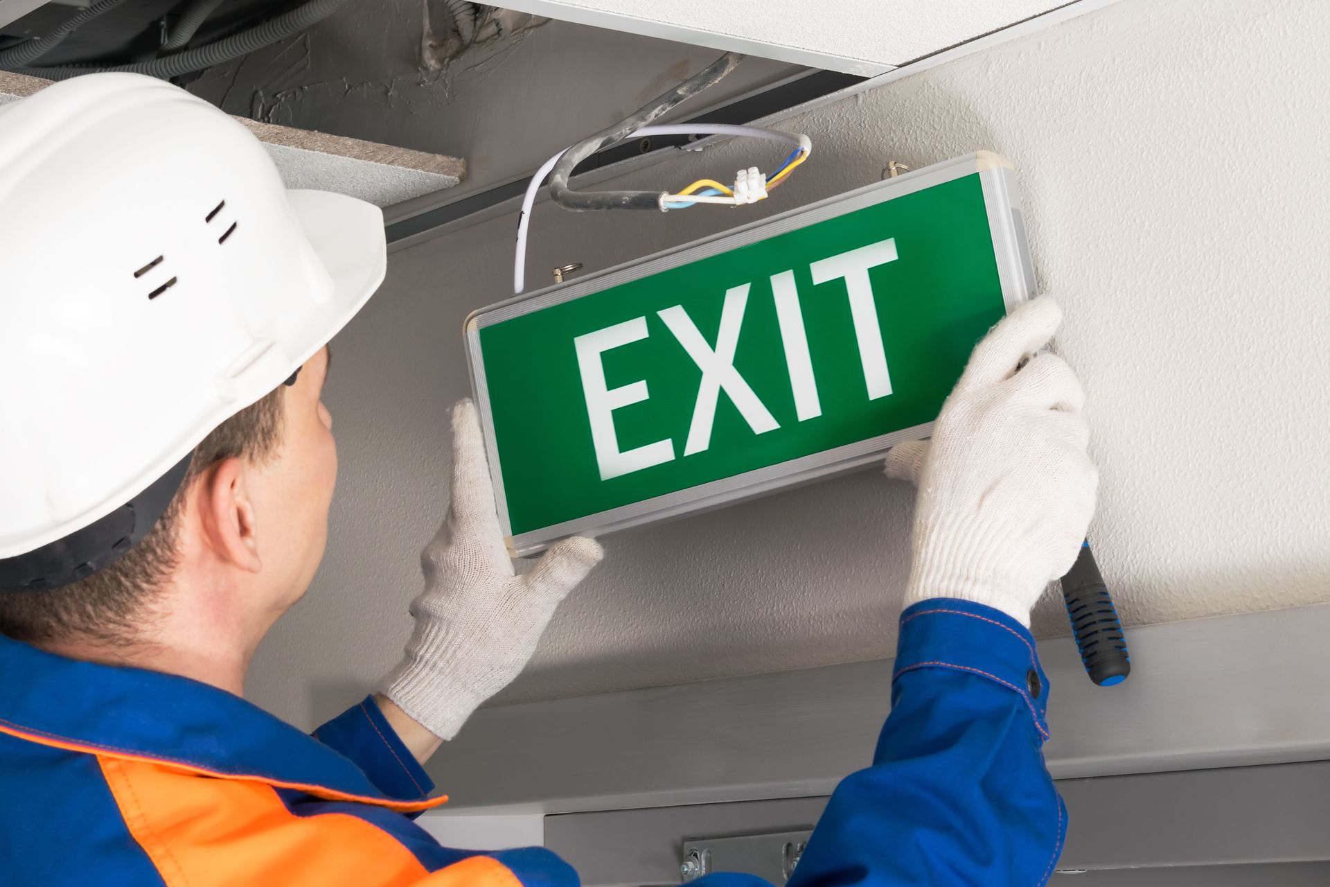 Worker in hard hat installing a green 