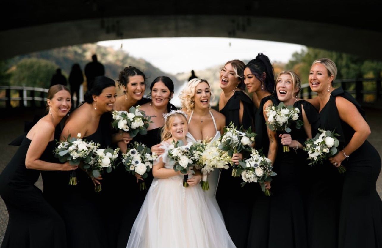 a bride and her bridesmaids are posing for a picture under a bridge . soft glam wedding makeup. pittsburgh, pa. bridal makeup. bridal mua. wedding makeup artist. moriah e beauty. alexa frankovitch photography.