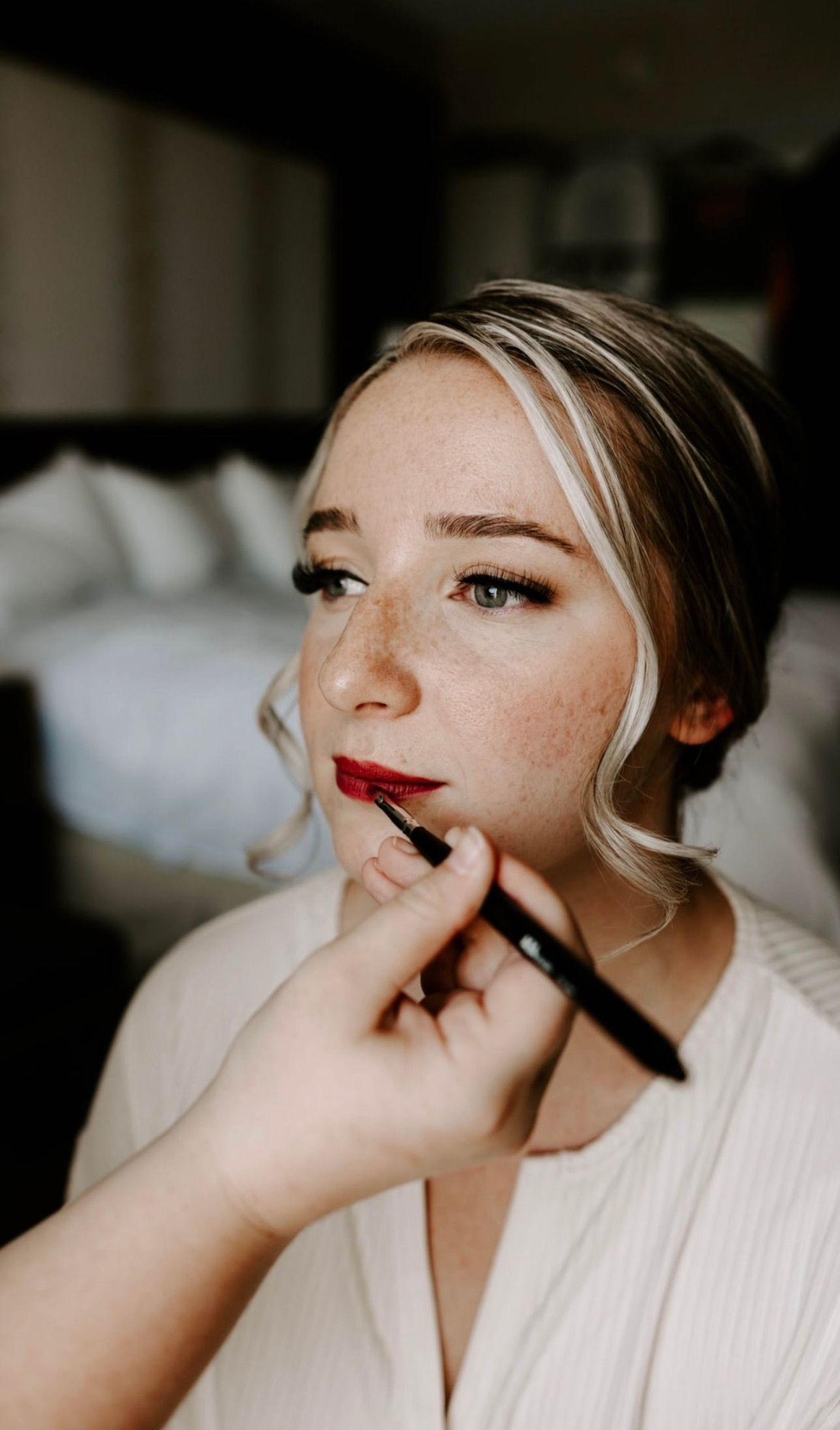 a bride is getting her makeup done by a makeup artist in a hotel room . natural wedding makeup. pittsburgh, pa. bridal makeup. bridal mua. wedding makeup artist. moriah e beauty. rachel wehan photography.