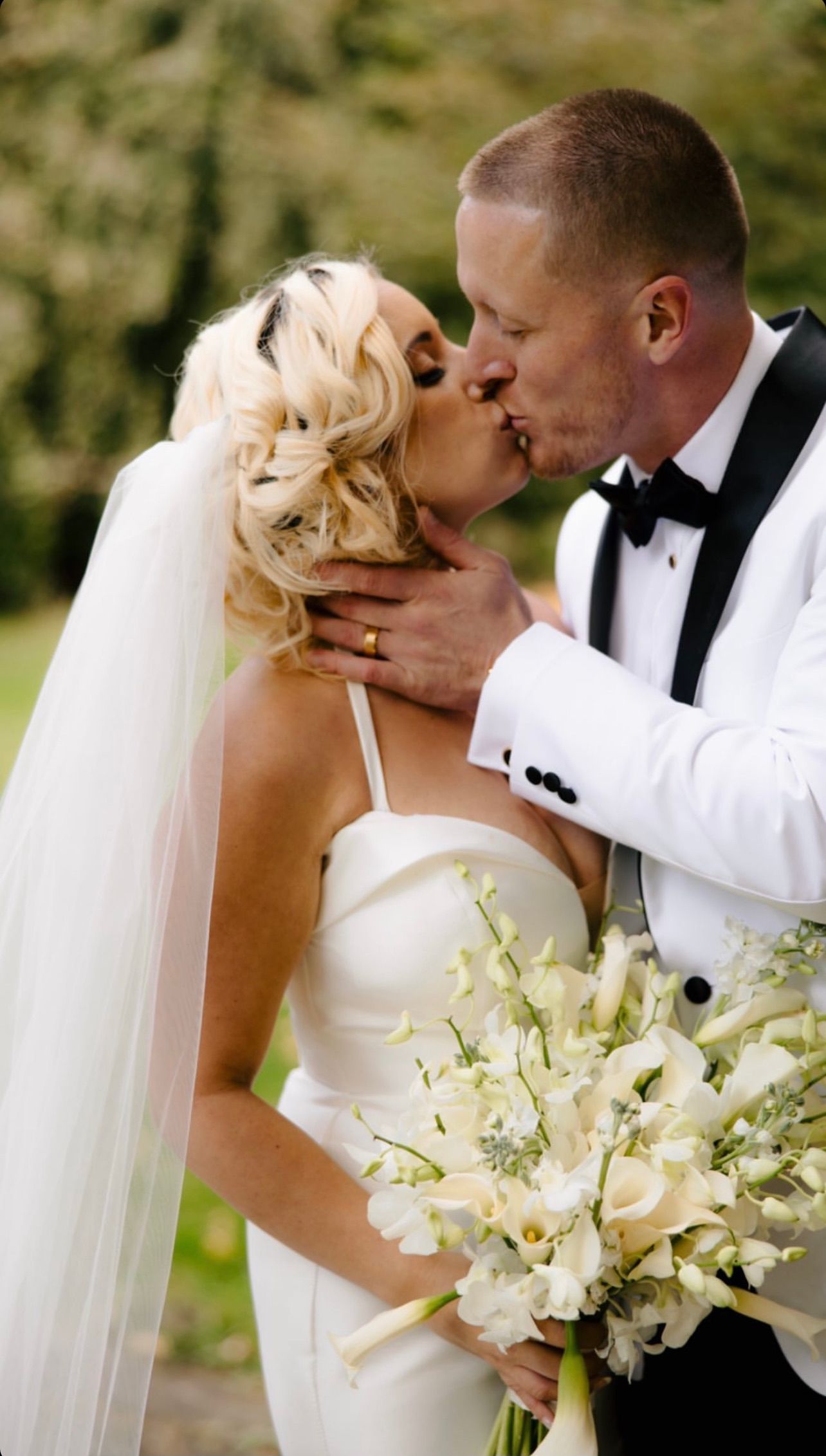 a bride and groom kissing while holding a bouquet of white flowers . soft glam wedding makeup. pittsburgh, pa. bridal makeup. bridal mua. wedding makeup artist. moriah e beauty. alexa frankovitch photography.