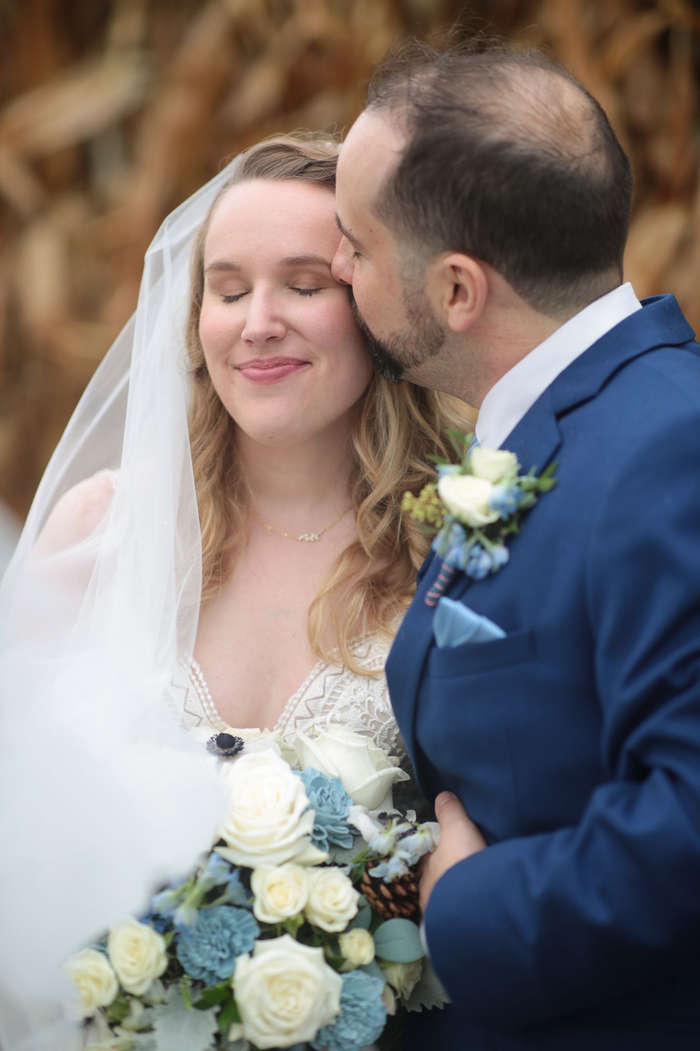a bride and groom are posing for a picture and the groom is kissing the bride on the cheek . natural wedding makeup. pittsburgh, pa. bridal makeup. bridal mua. wedding makeup artist. moriah e beauty. kristen wynn photography.