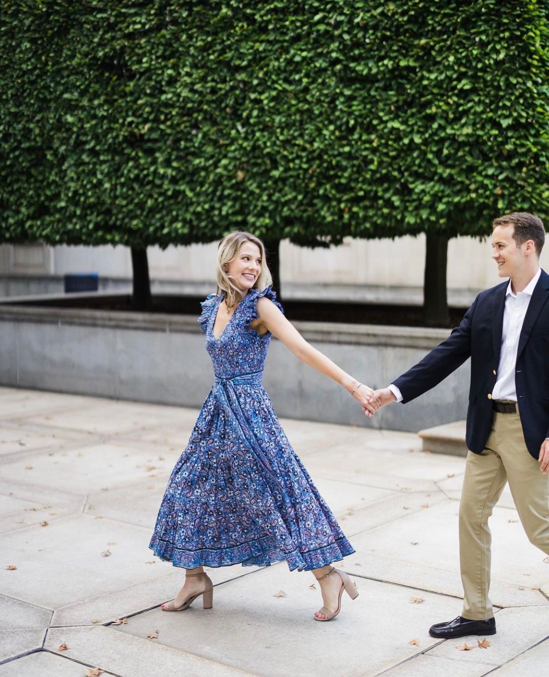 a man and a woman are holding hands while walking down a sidewalk .  natural wedding makeup. pittsburgh, pa. bridal makeup. bridal mua. wedding makeup artist. moriah e beauty. steven dray photography.