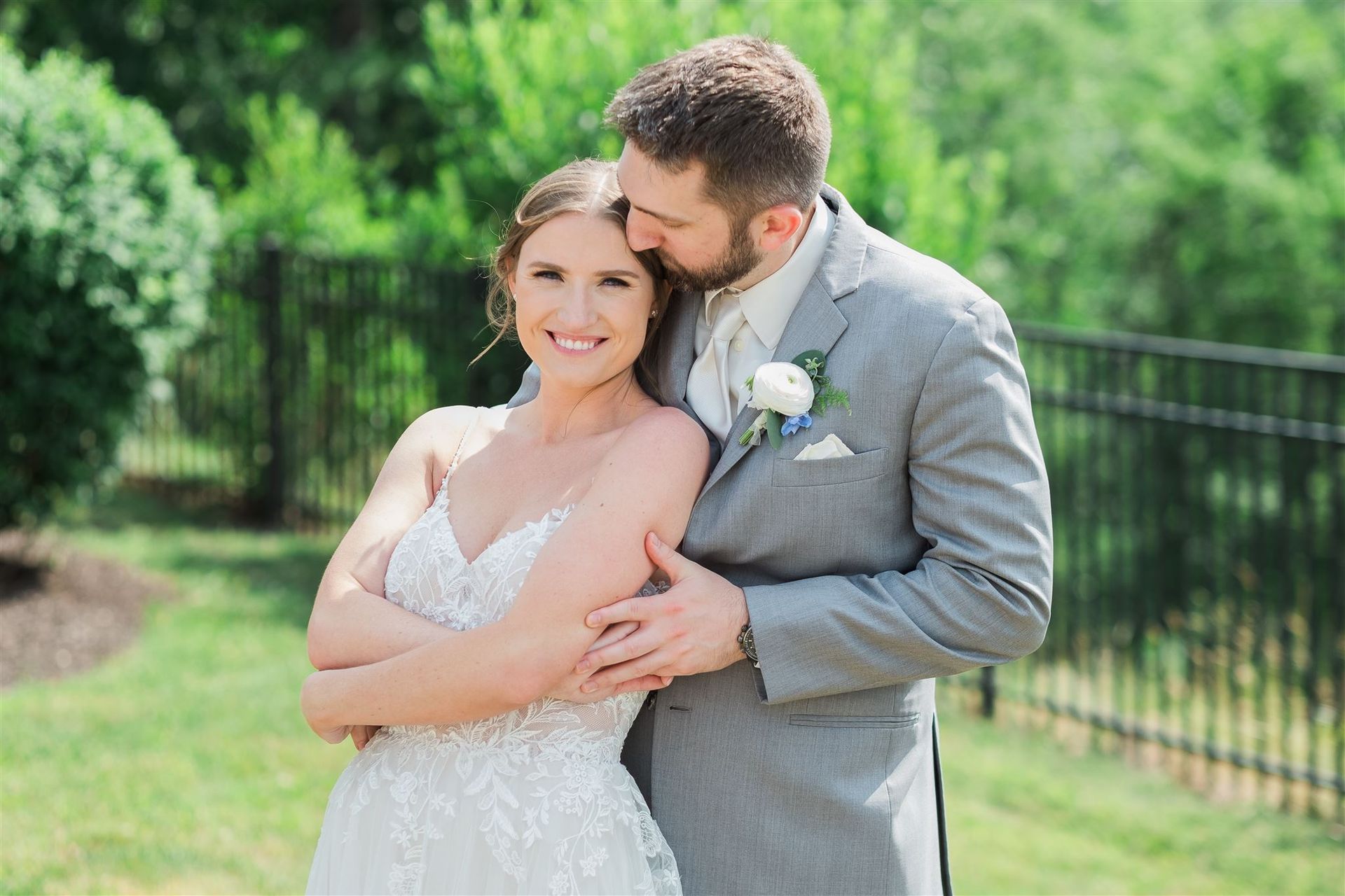 a bride and groom are posing for a picture and the groom is kissing the bride on the forehead . natural wedding makeup. pittsburgh, pa. bridal makeup. bridal mua. wedding makeup artist. moriah e beauty. caitlin's living photography.