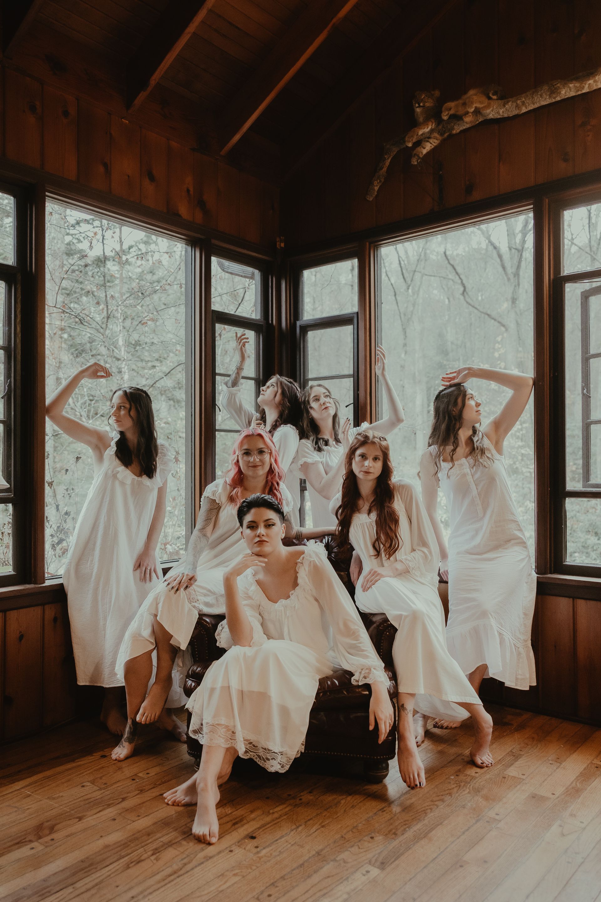 a bride and her bridesmaids in white dresses are posing for a picture in a room . glam wedding makeup. pittsburgh, pa. bridal makeup. bridal mua. wedding makeup artist. moriah e beauty. snaps by shawna photography.