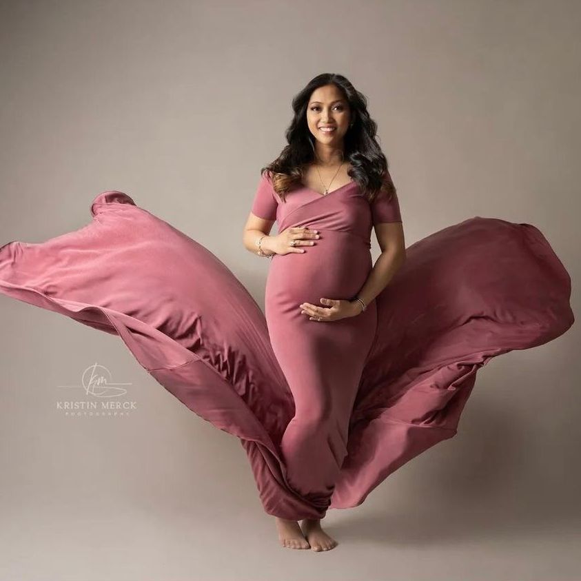 a pregnant woman in a pink dress is flying through the air . natural makeup. pittsburgh, pa. maternity makeup. bridal mua. wedding makeup artist. moriah e beauty. kristin merck photography.