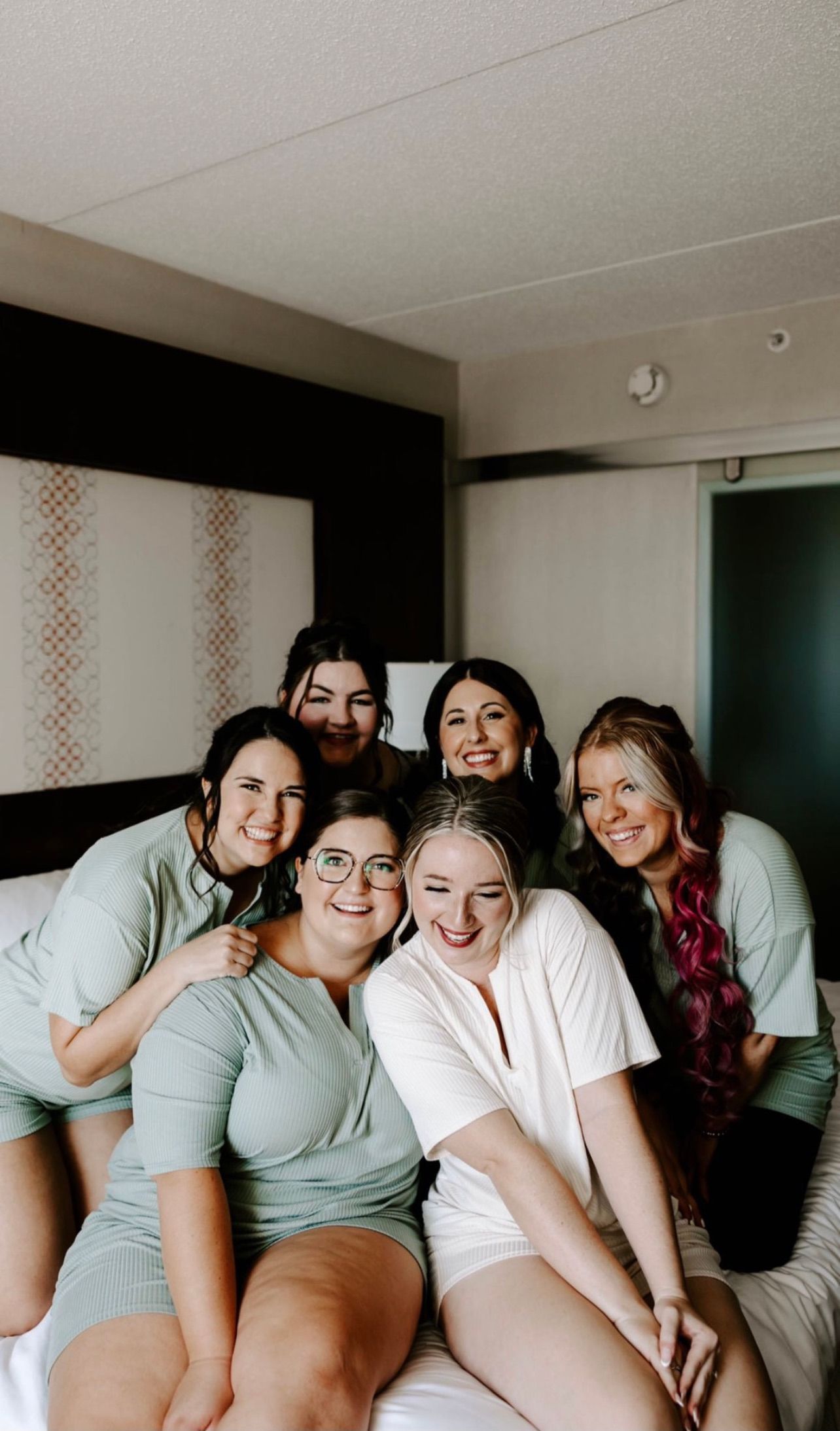 a group of women are posing for a picture while sitting on a bed . natural wedding makeup. pittsburgh, pa. bridal makeup. bridal mua. wedding makeup artist. moriah e beauty. rachel wehan photography.