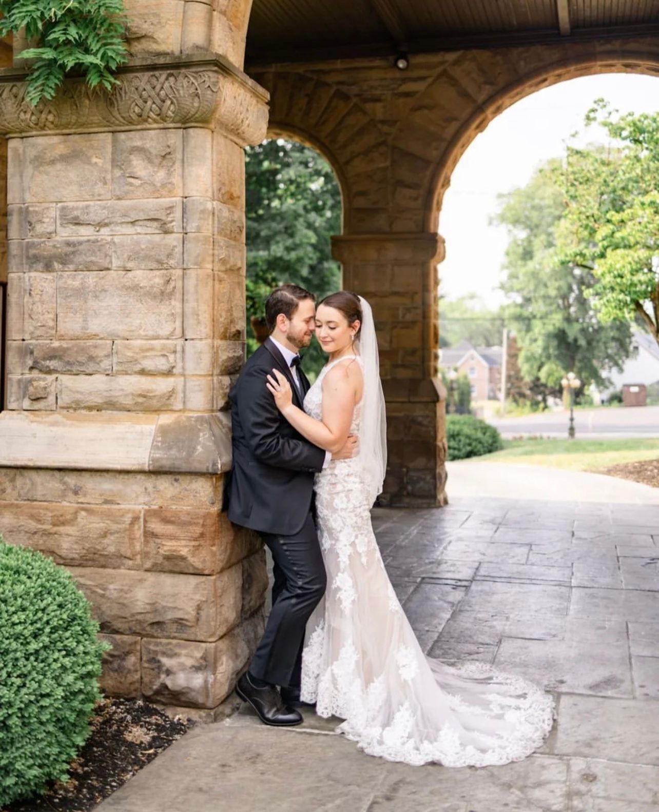a bride and groom are leaning against a stone wall . natural wedding makeup. pittsburgh, pa. bridal makeup. bridal mua. wedding makeup artist. moriah e beauty. danielle durbin film and photo.