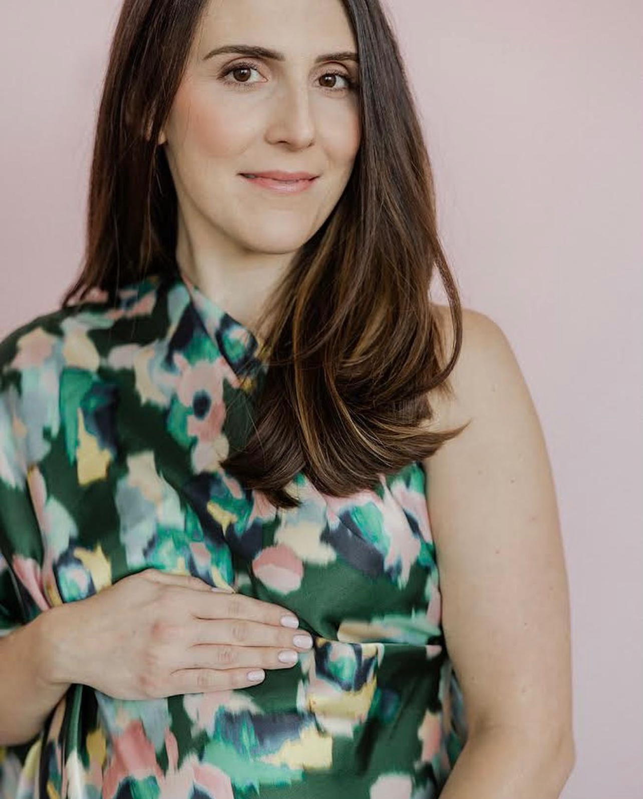 a pregnant woman in a green floral dress is holding her belly . natural makeup. pittsburgh, pa. maternity makeup. bridal mua. wedding makeup artist. moriah e beauty. loren demarco photography.