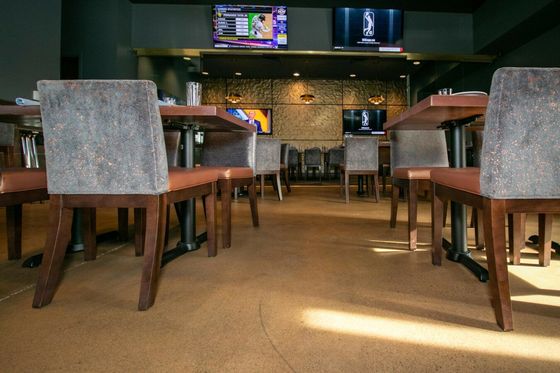 A restaurant with tables and chairs and a television on the wall.