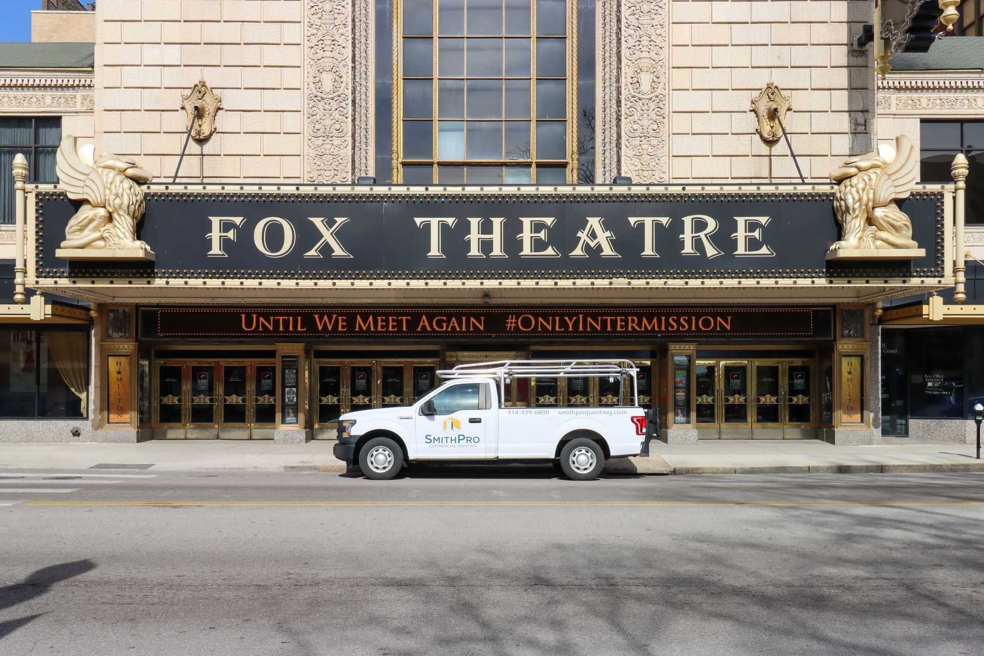 A white truck is parked in front of the fox theatre