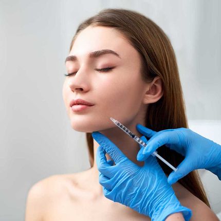 Smile lifting and lip augmentation. Beautician doctor hands doing beauty procedure to female face with syringe. 