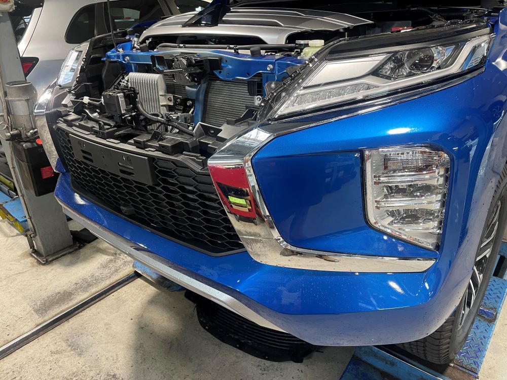 A Blue Car With the Hood Open is Sitting on a Lift in a Garage — VR Mechanical in West Gosford, NSW