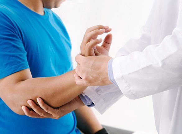 Doctor Checking Patient's Wrist — State College, PA — Back To Life Physical Therapy