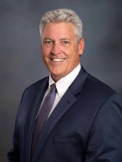 A man in a suit and tie is smiling for the camera