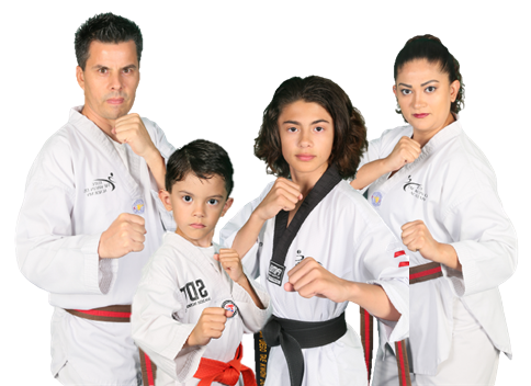 A family of four in taekwondo uniforms are posing for a picture.