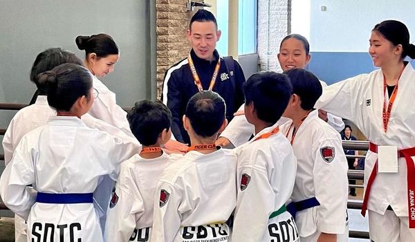 A group of people in karate uniforms are standing in a huddle.