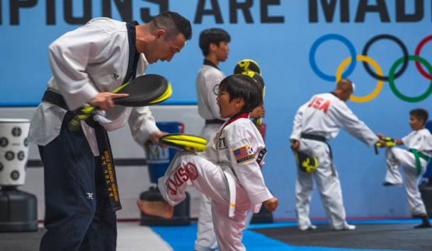 A group of people are practicing martial arts in front of a sign that says champions are mad