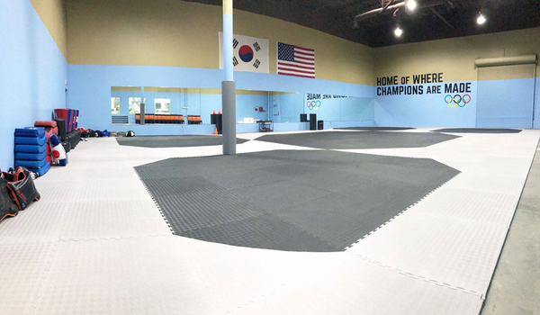 A gym with a sign on the wall that says champions are made