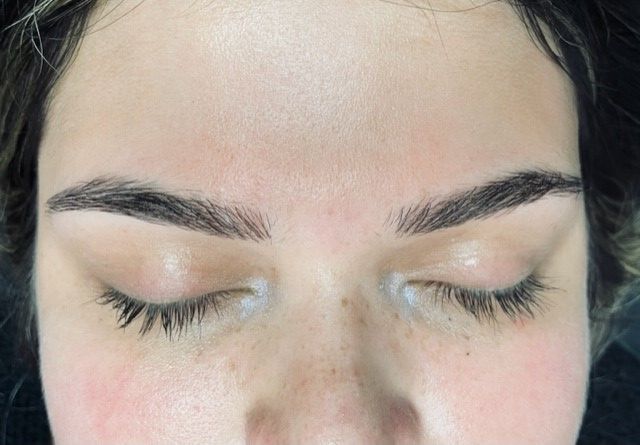 A close up of a woman 's face with her eyes closed.
