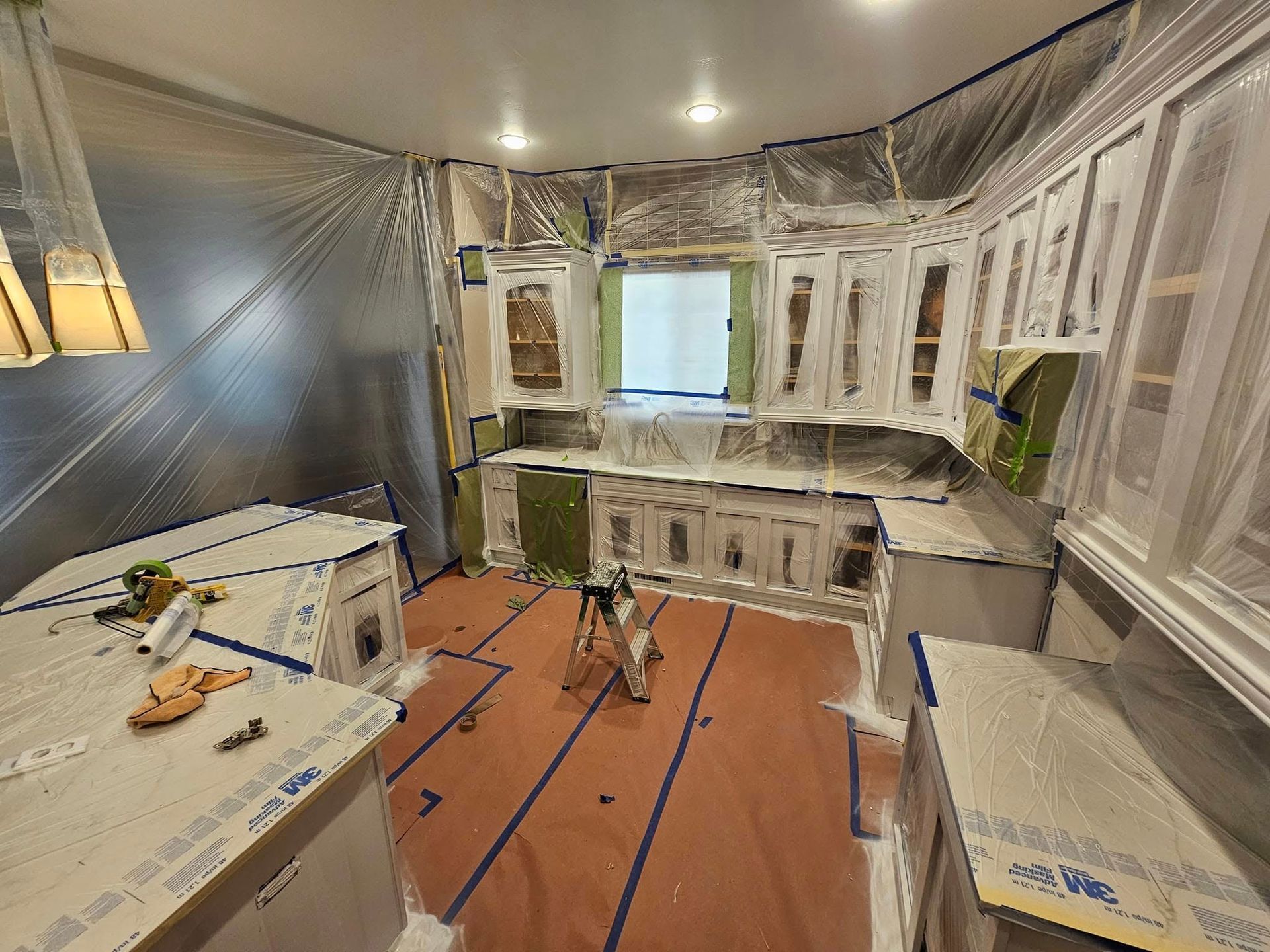 Woman in straw hat smiles, holding wine glass near a lake.