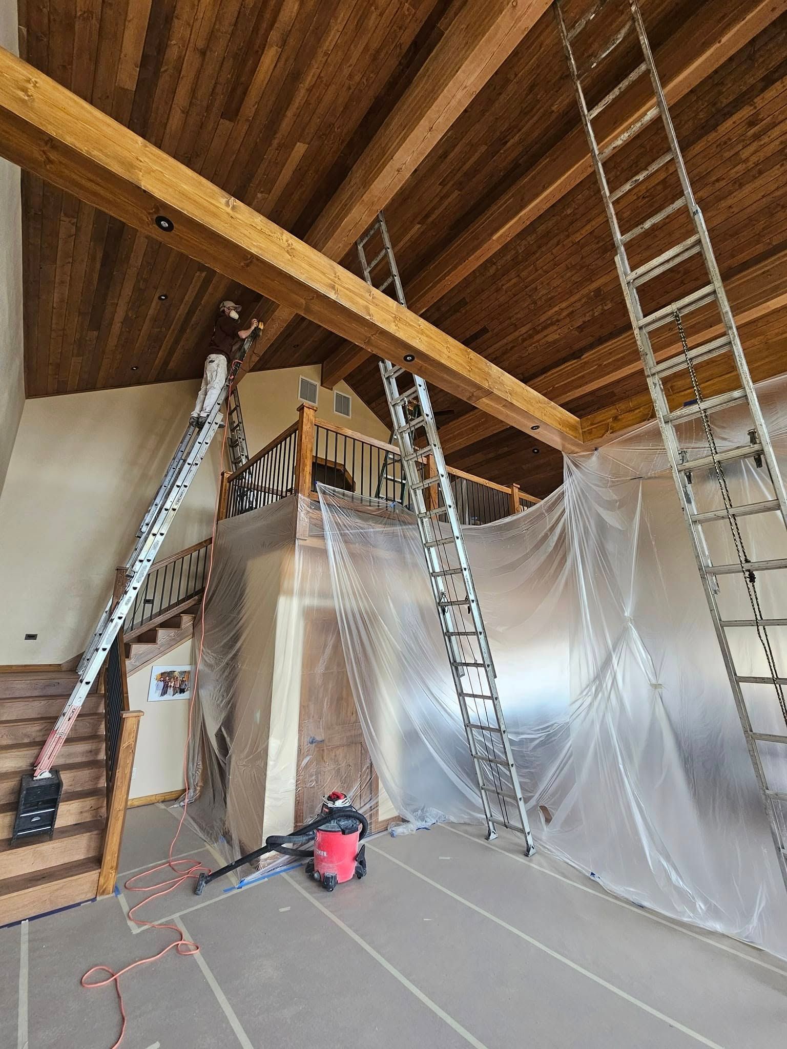 Woman in straw hat smiles, holding wine glass near a lake.