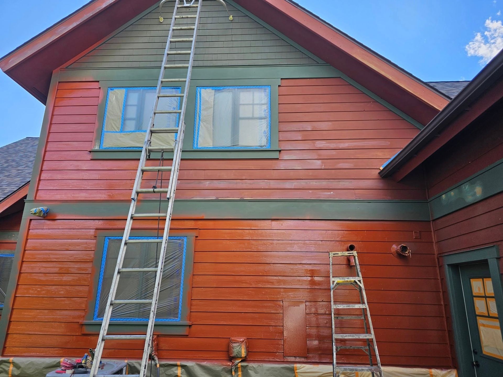 Woman in straw hat smiles, holding wine glass near a lake.