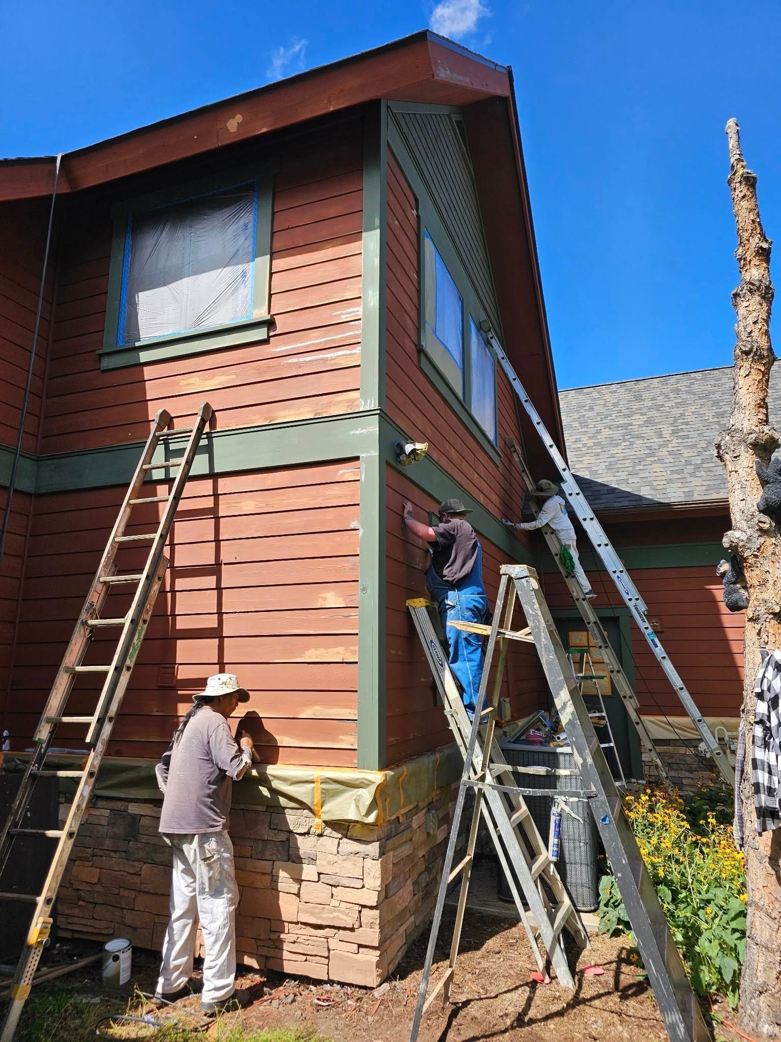 Woman in straw hat smiles, holding wine glass near a lake.