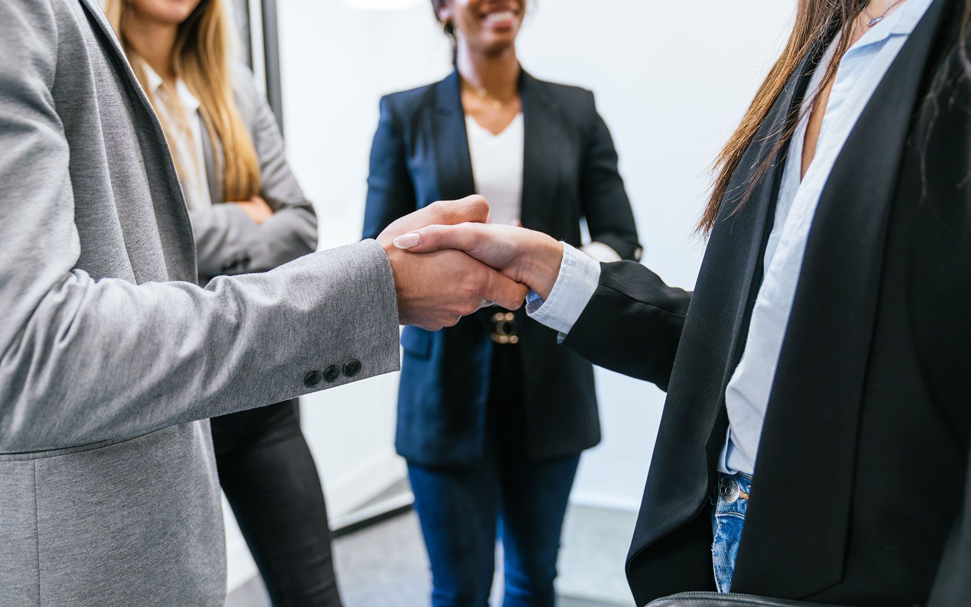 A group of business people are shaking hands in an office.