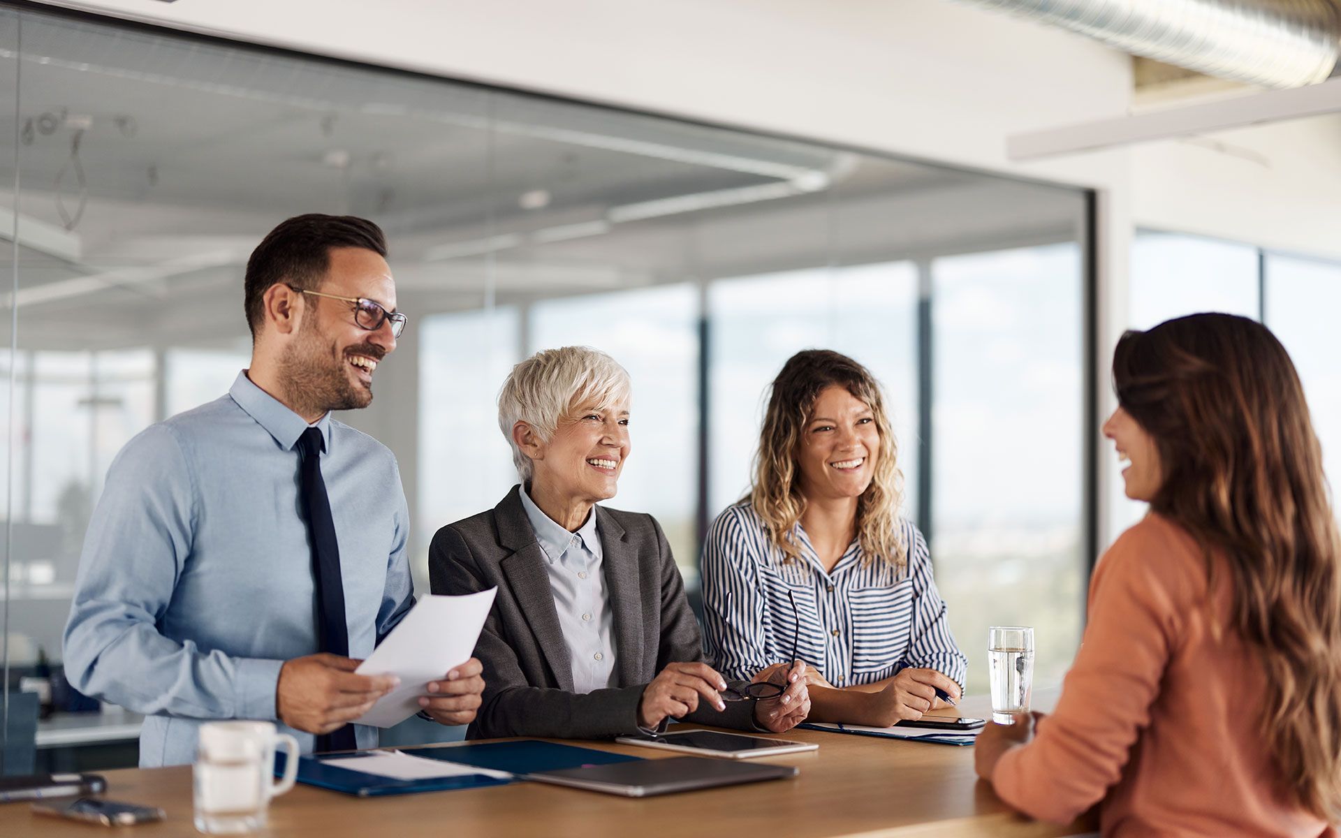 A group of people are sitting around a table having a job interview.