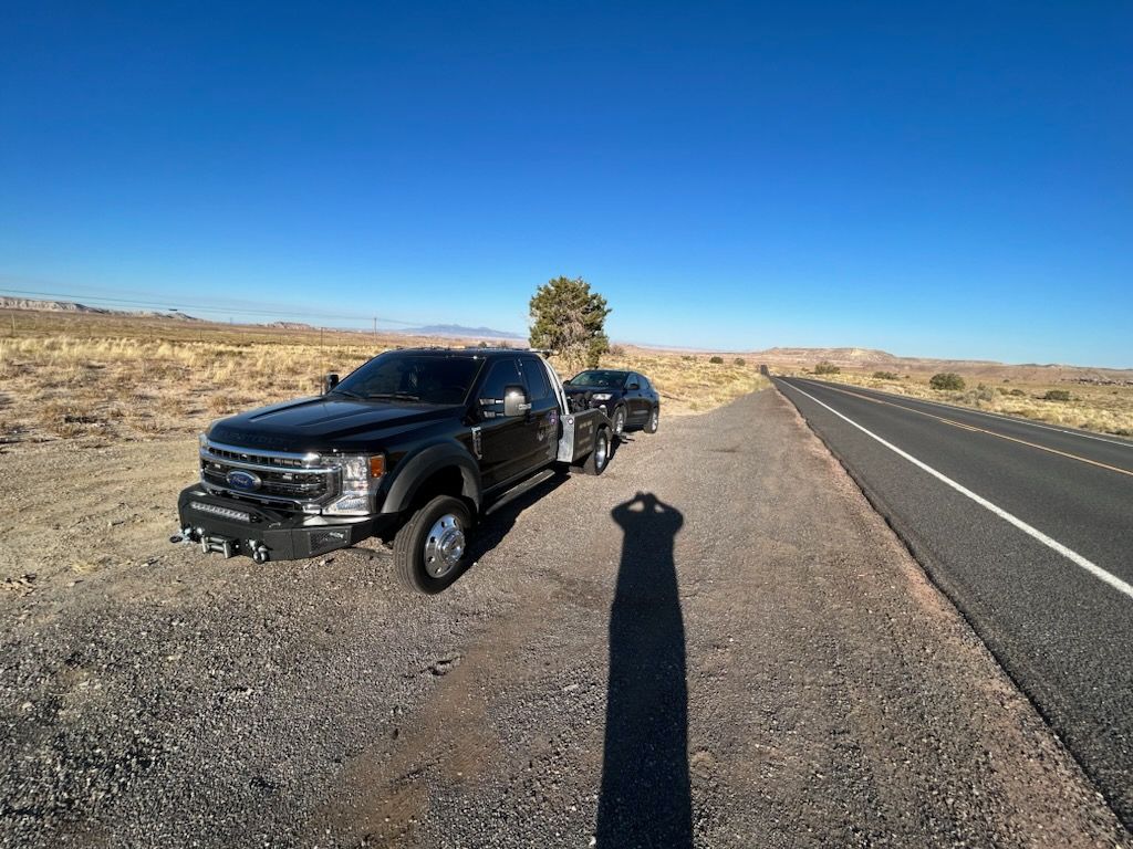 Two trucks are parked on the side of the road.