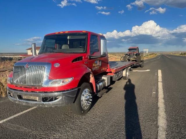 A red tow truck is parked on the side of the road