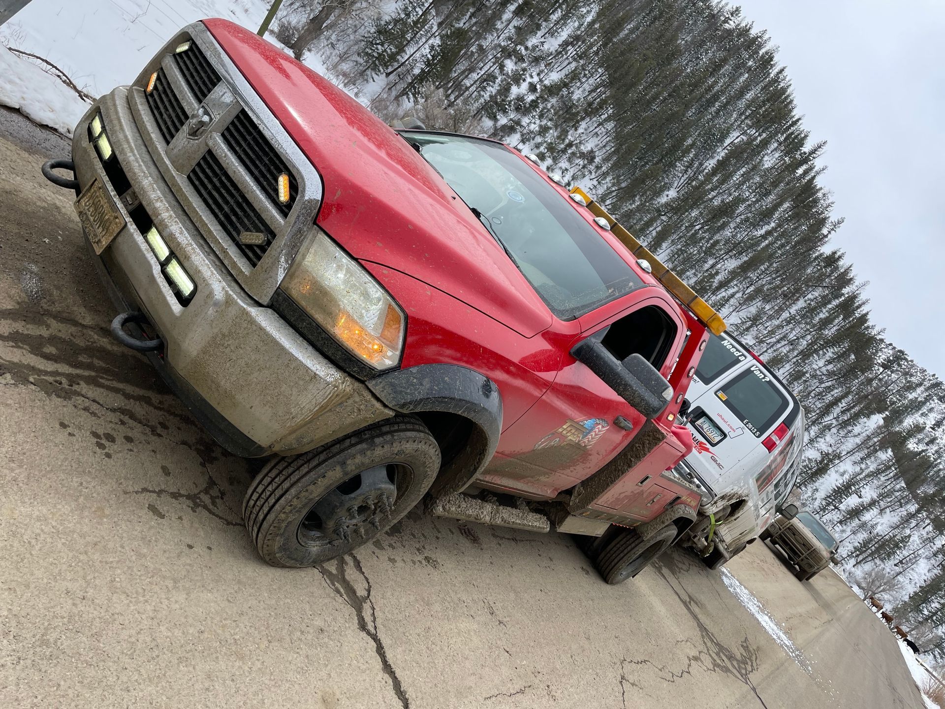 A red tow truck is parked on the side of the road.