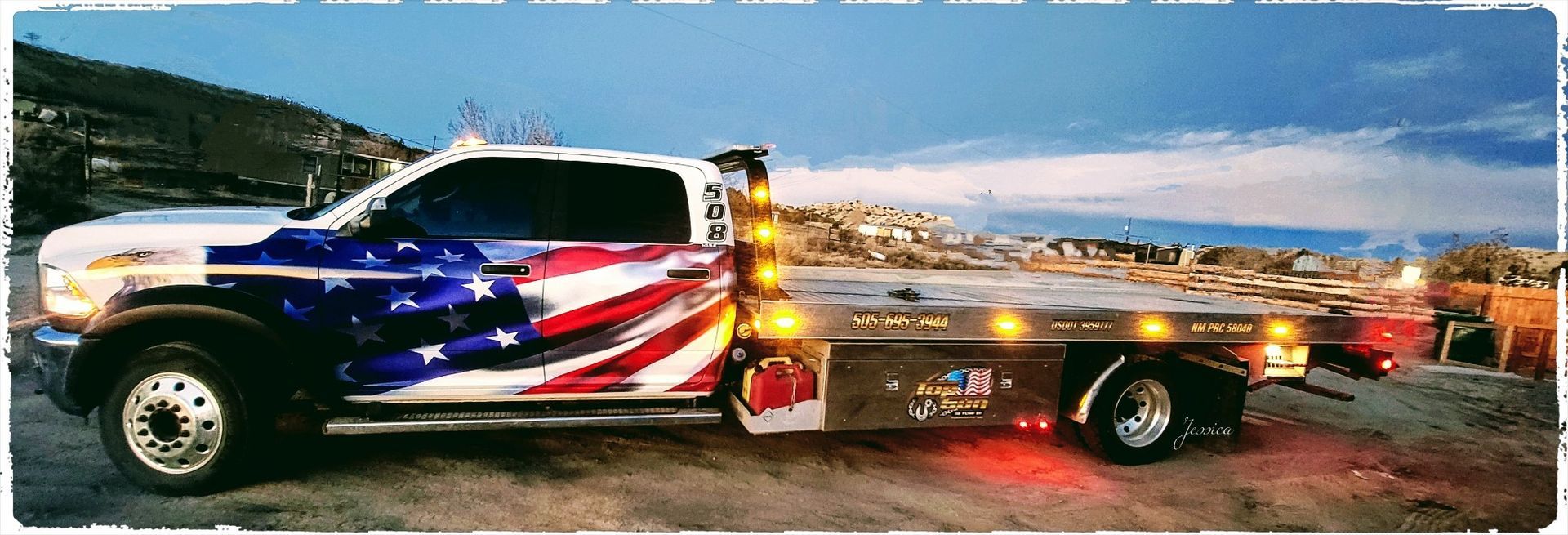 A tow truck with an american flag painted on it