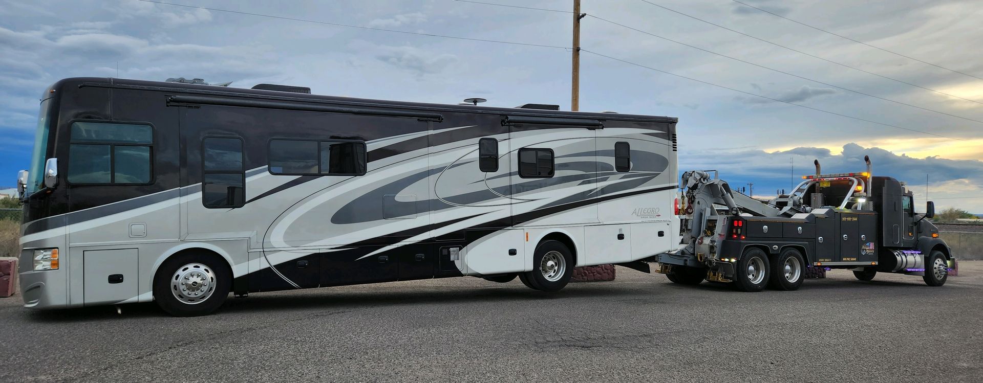 A large rv is being towed by a tow truck.