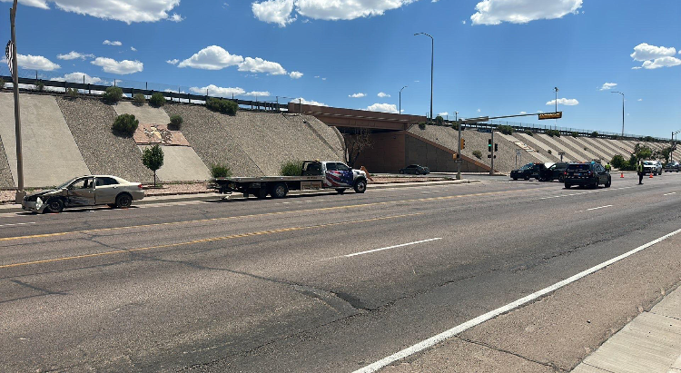 A car is sitting on the side of the road next to a truck.