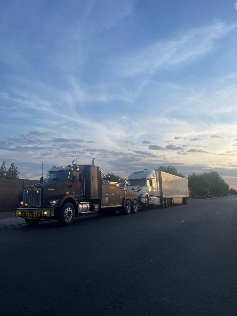 A semi truck with a trailer attached to it is parked on the side of the road.