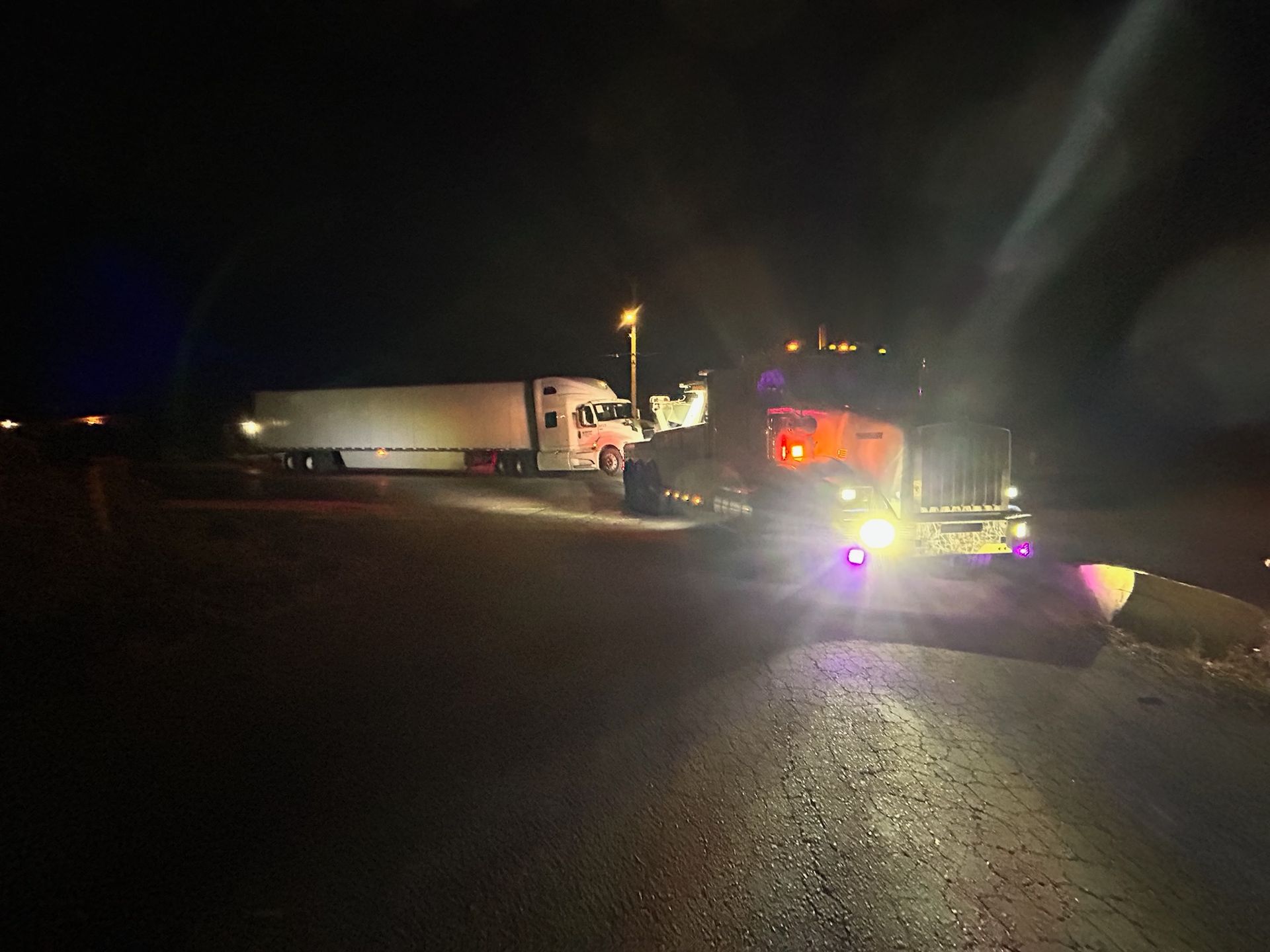 A truck is driving down a highway at night.