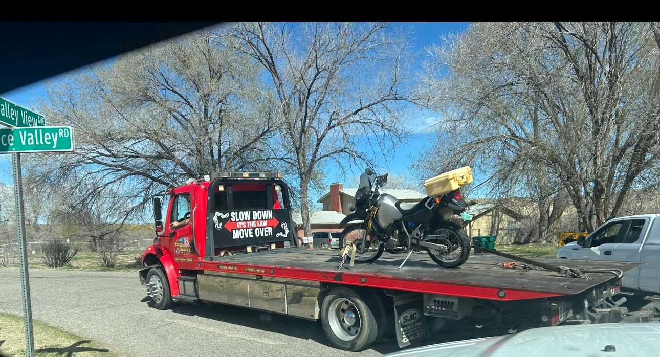 A tow truck with a motorcycle on the back of it.