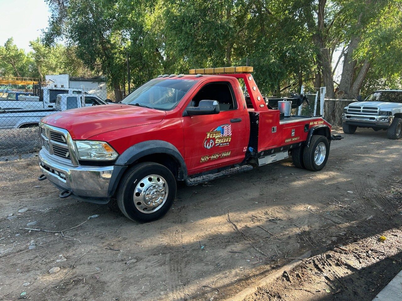 A red tow truck is parked on the side of the road.