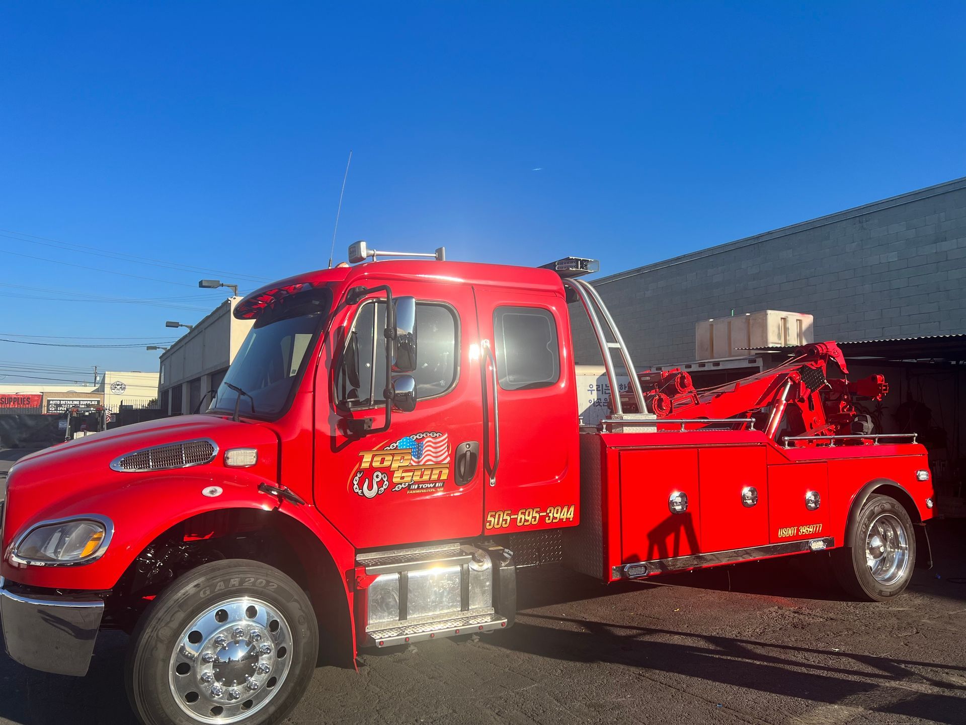 A red tow truck is parked in front of a building.