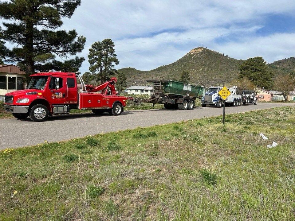 A red tow truck is parked on the side of the road