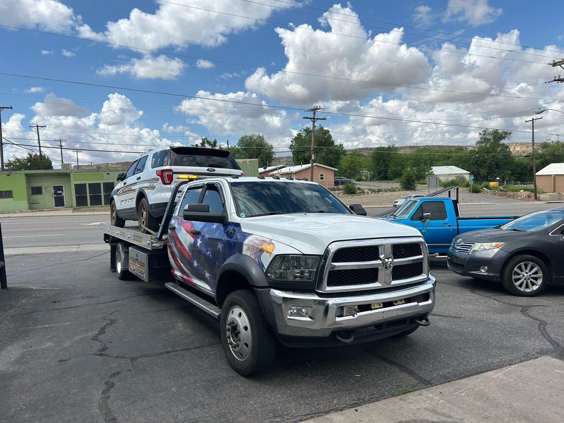 A tow truck is carrying a car on the back of it.