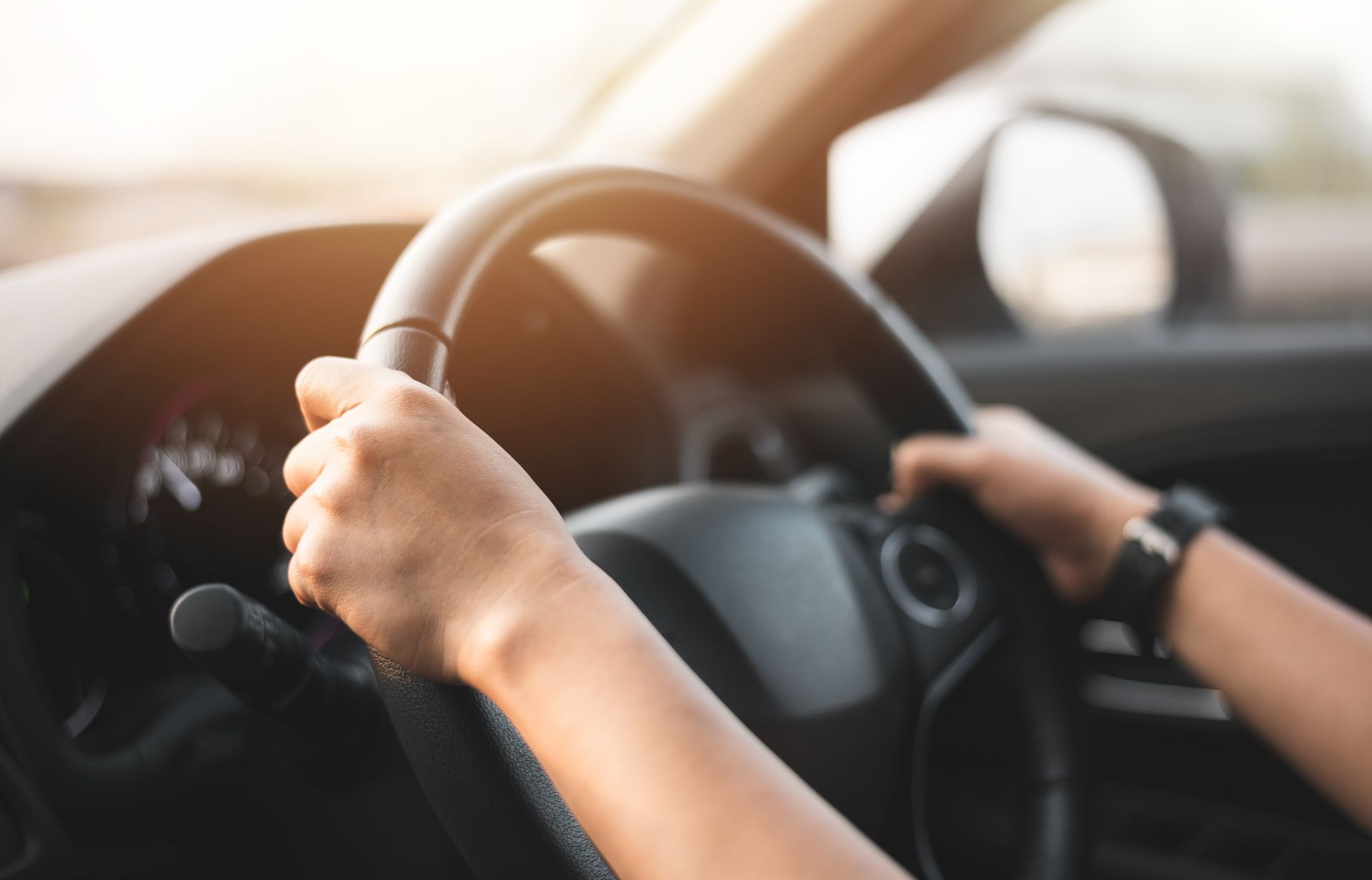 Partial view of a woman holding a steering wheel at a driving school. Partial view of a woman holding a steering wheel at a driving school.