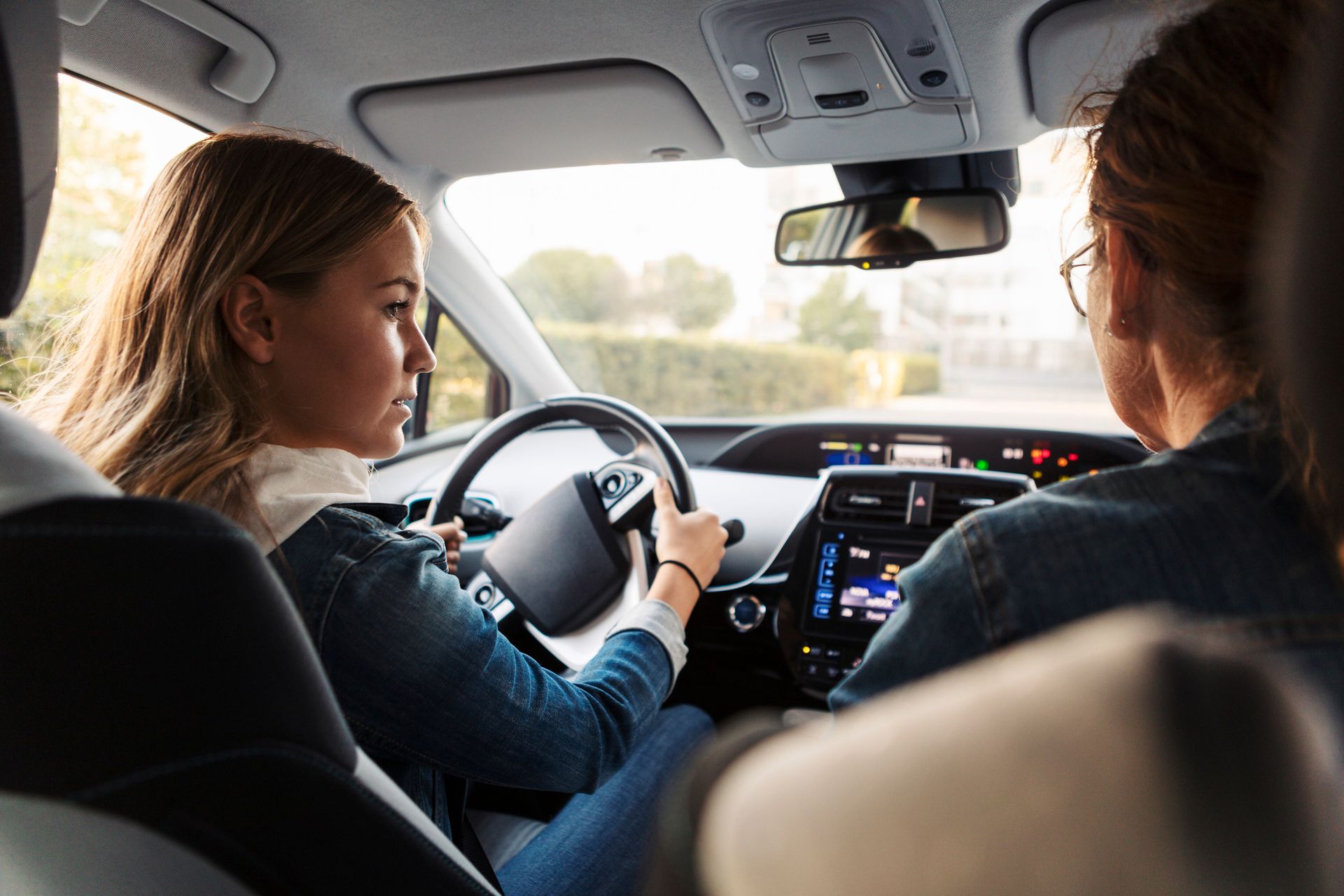 A teenage girl is learning to drive.