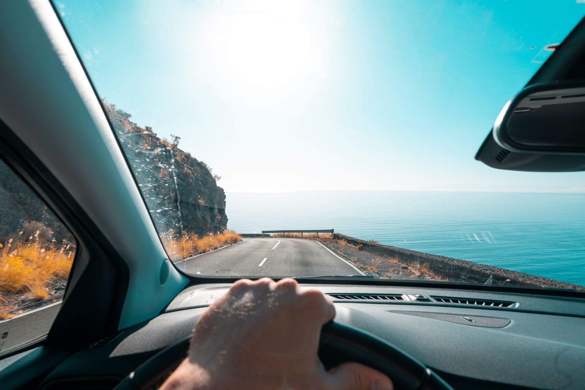 A perspective of a person driving along the coast.