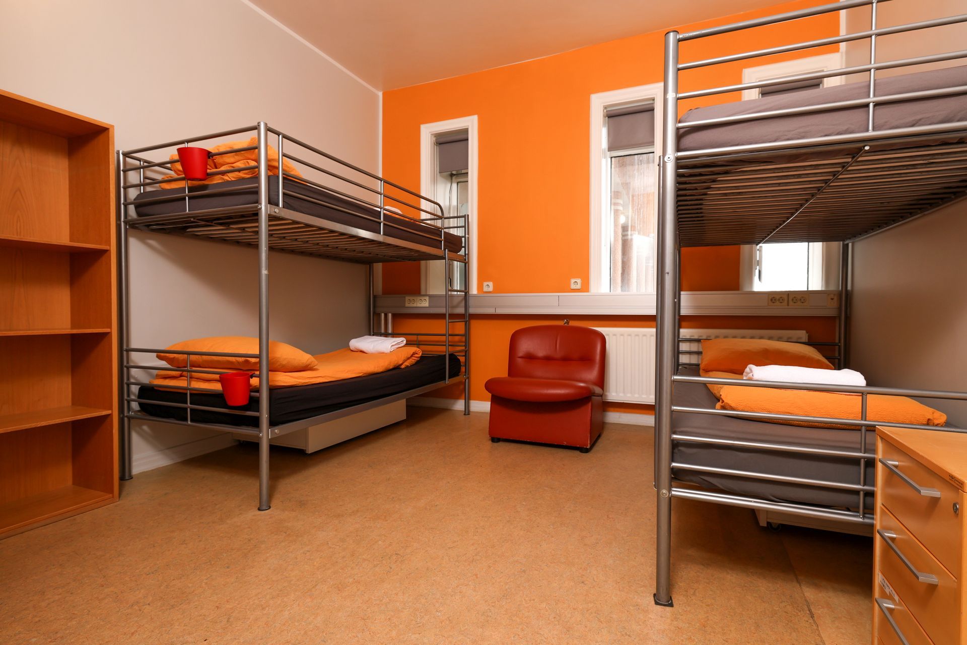 A room with four bunk beds and a chair