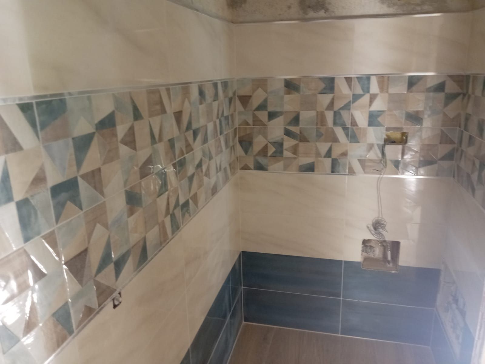 un bagno con piastrelle geometriche sulle pareti e sul pavimento .