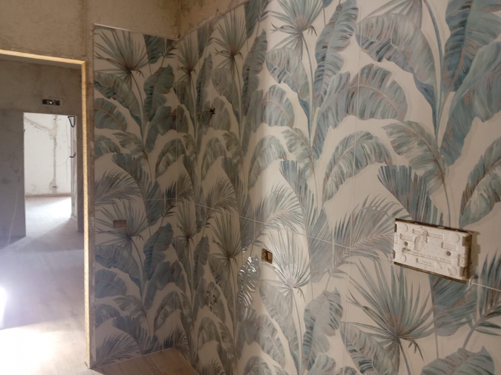 un muro con un motivo di foglie blu e bianche su di esso .