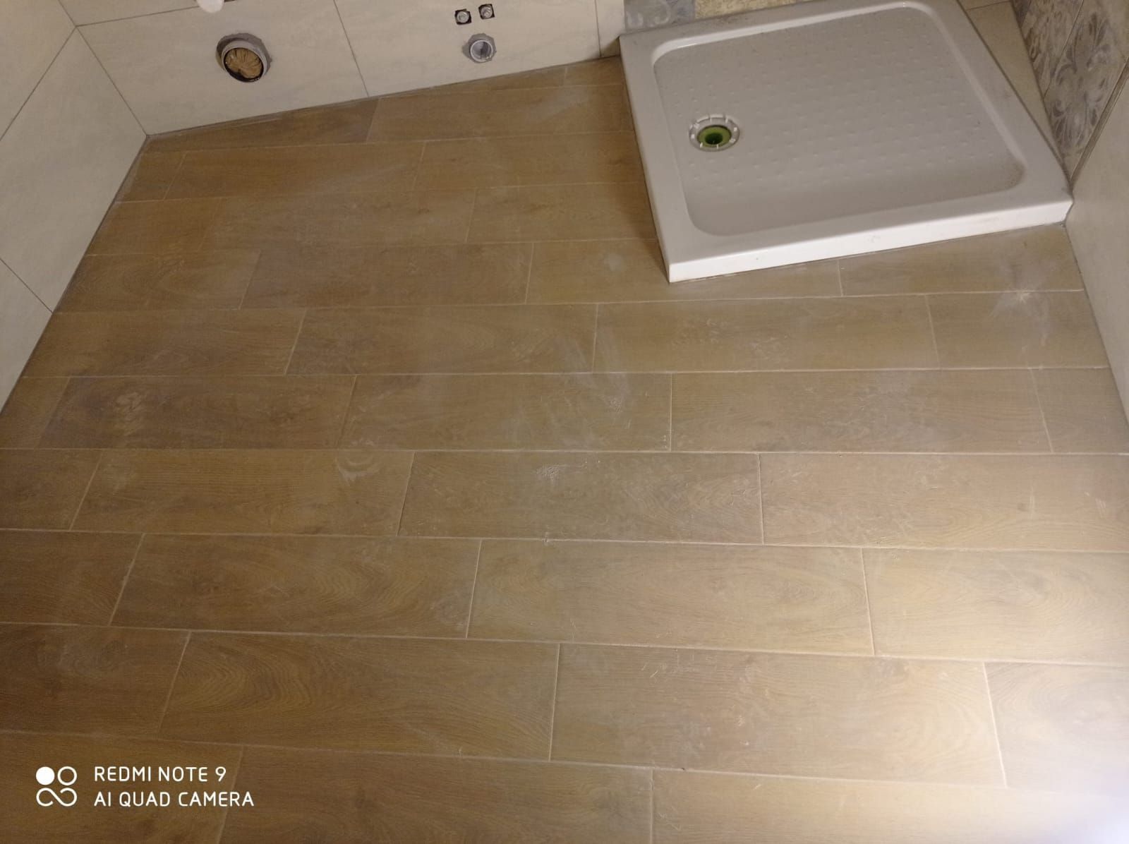 un bagno con piastrelle marroni e una doccia bianca .